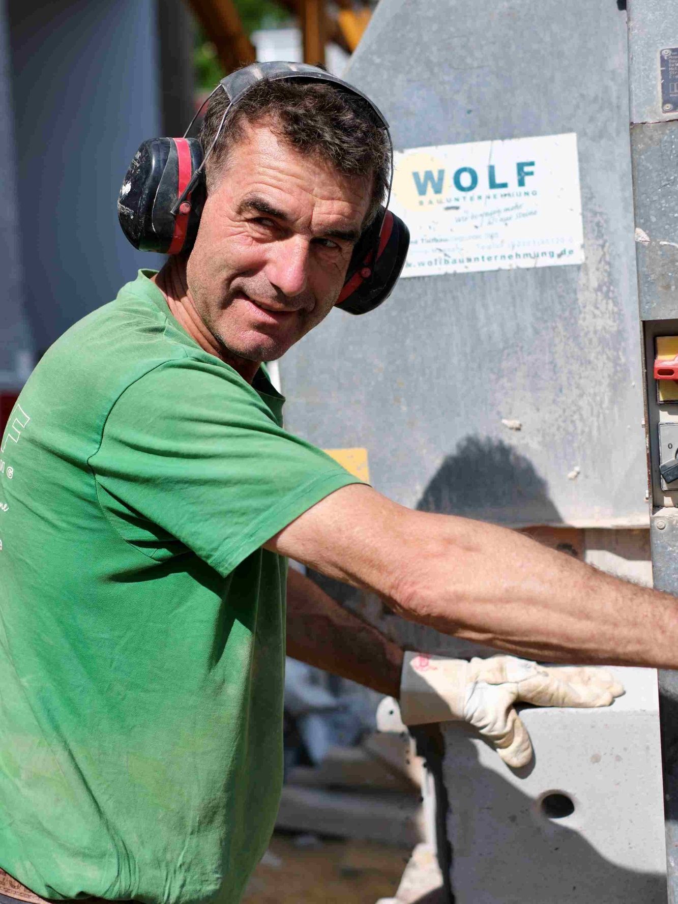 Stellenangebote Einschaler in Unna Mann in grüner T-Shirt mit Kelle, leicht bekleidet und mit Bauarbeiter-Aussehen.